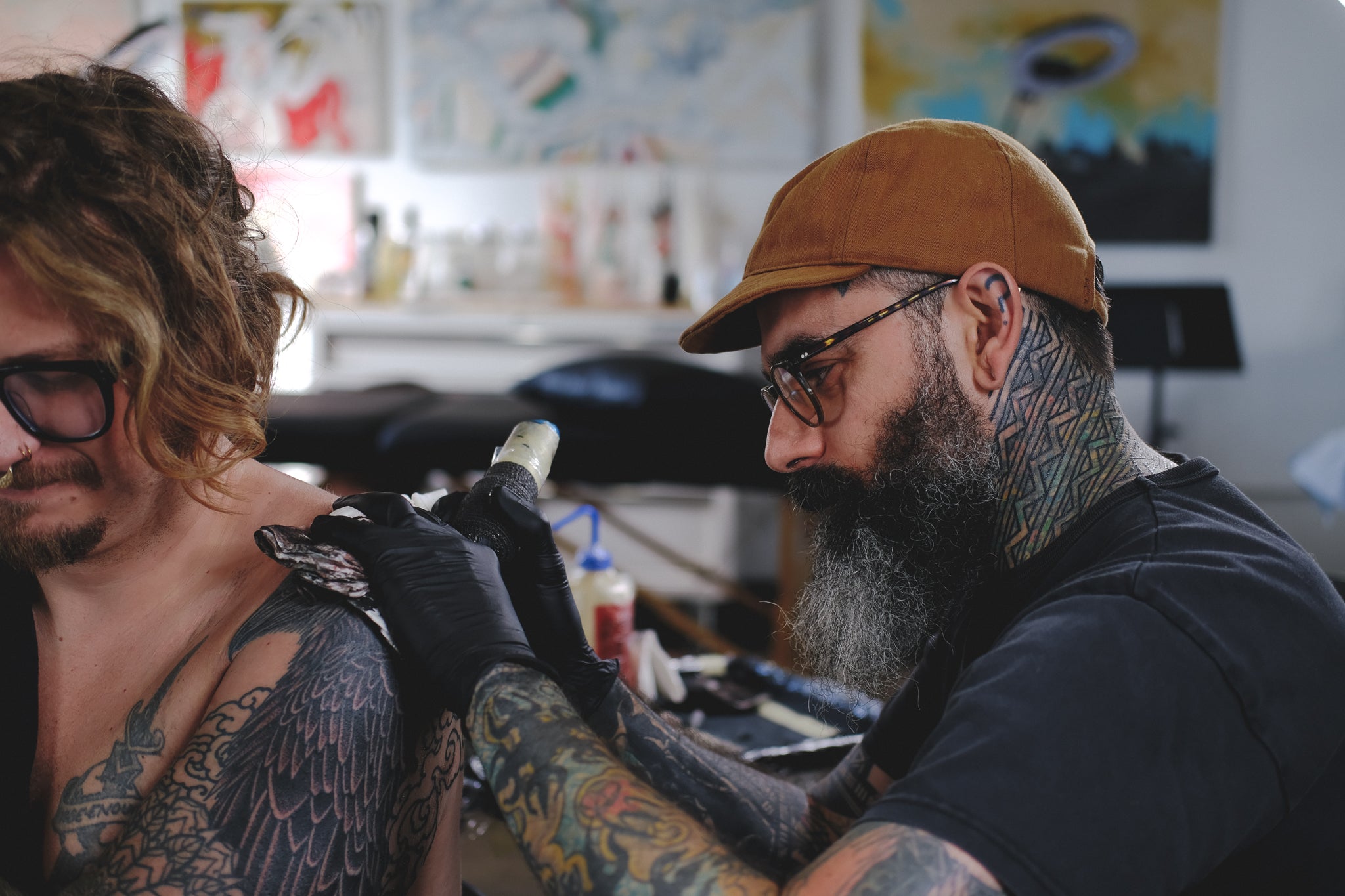 Thomas Hooper tattoos a client in a studio.