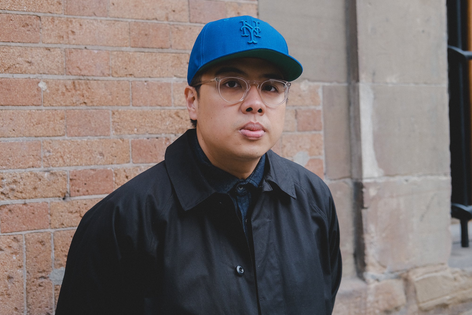 A portrait of a man in a blue cap and black coat.