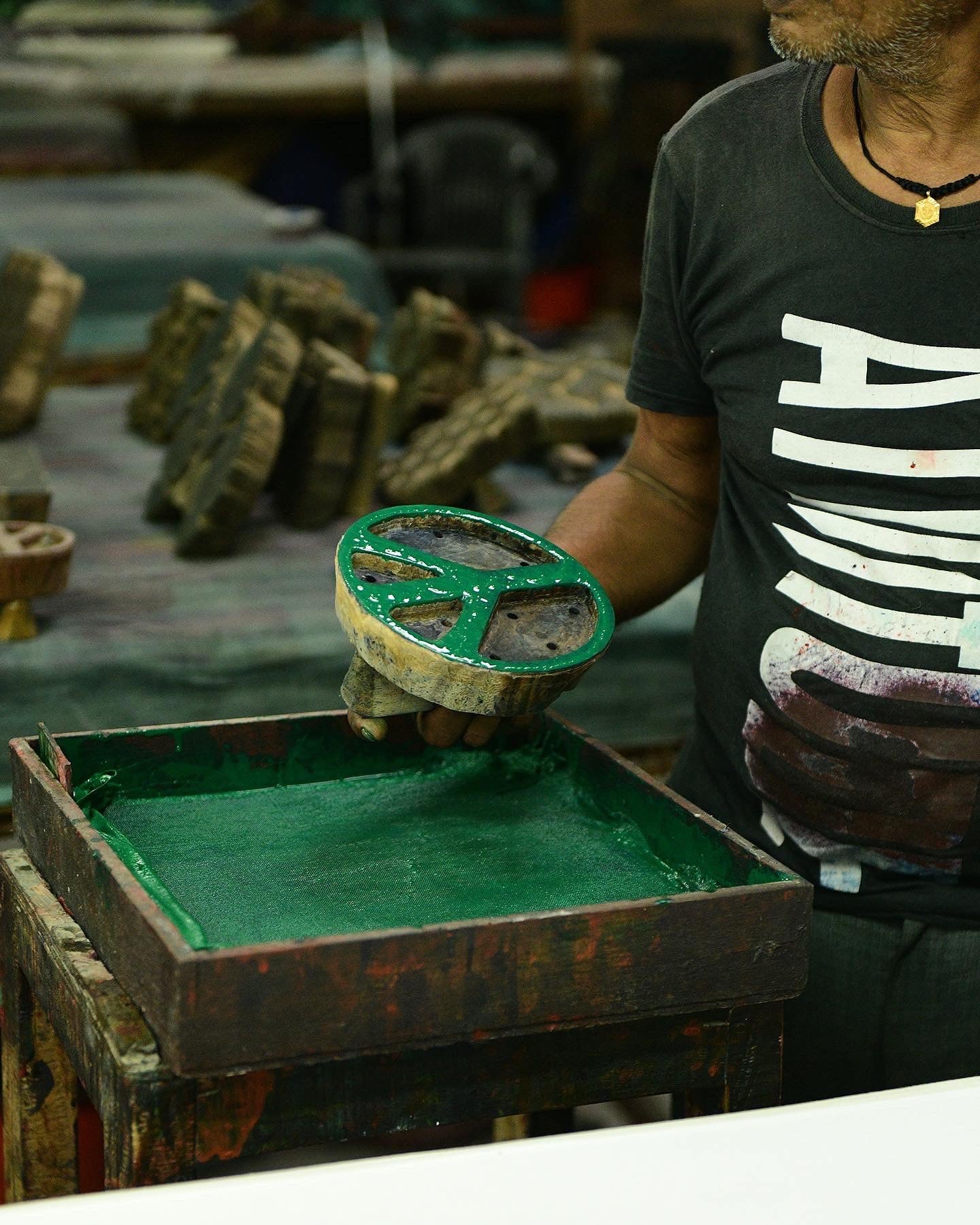 A close up of a wooden peace sign block dipped in green ink.