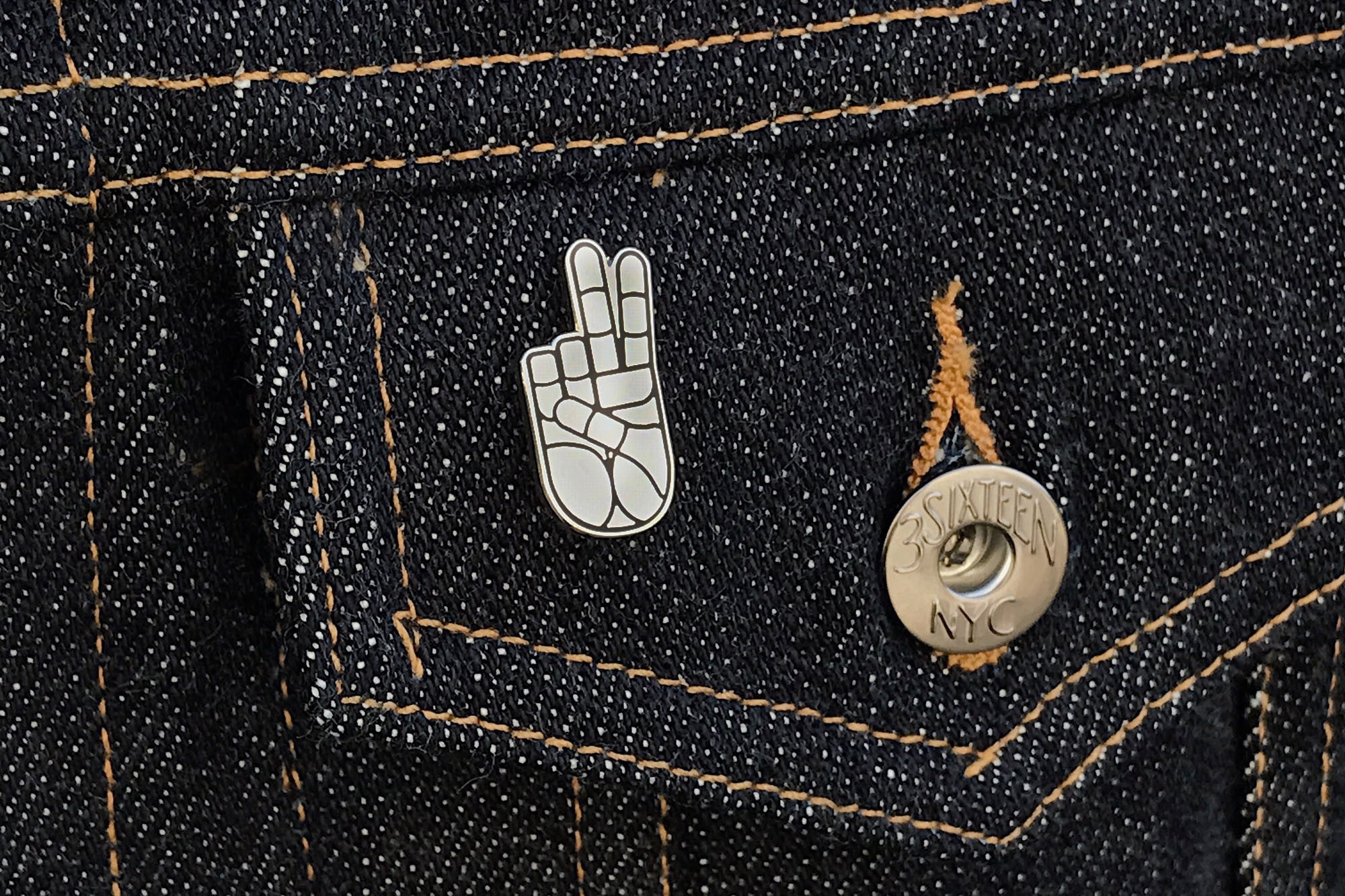 Close of view of peace pin on jacket pocket.