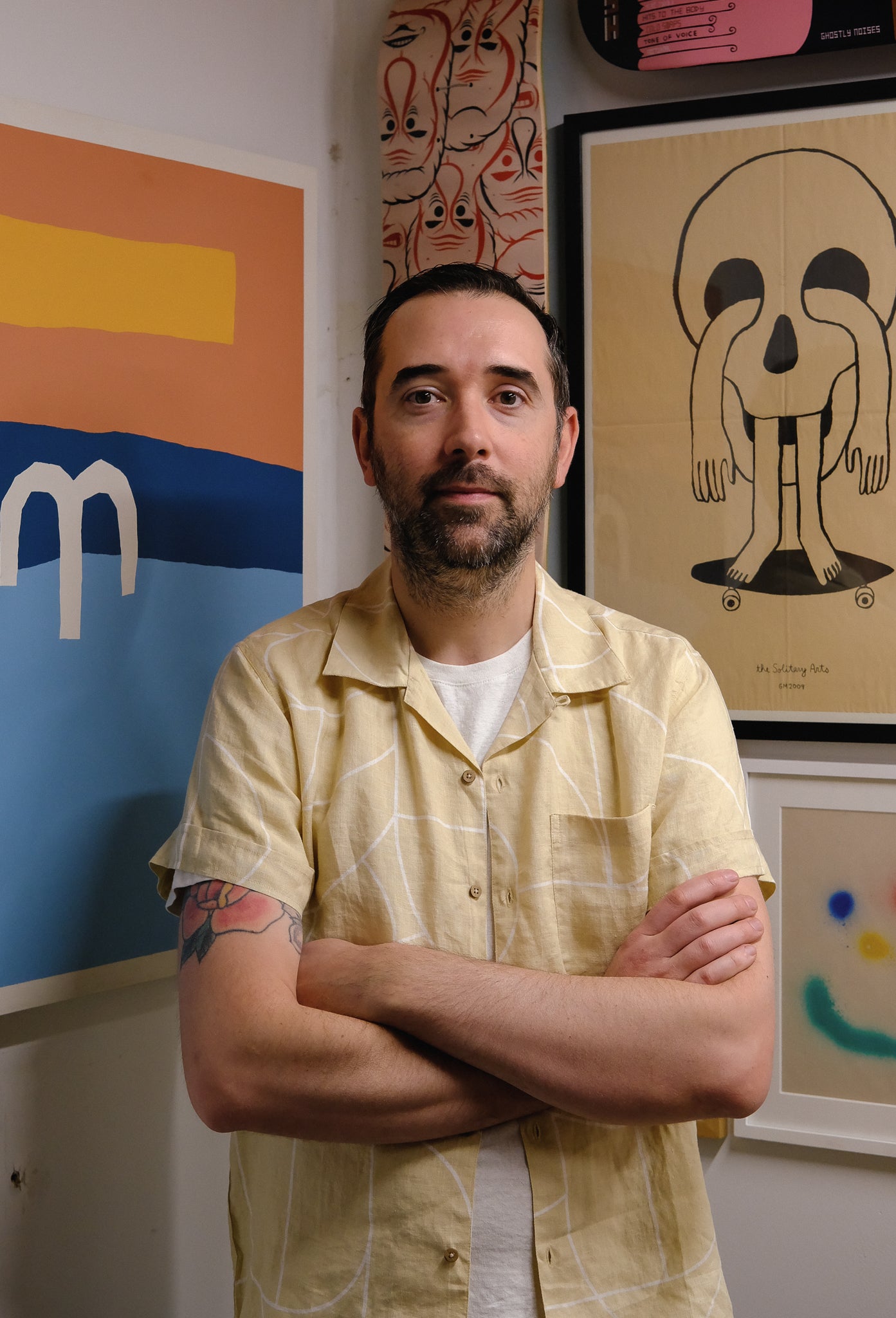 A portrait of Scott in his studio surrounded by colorful artwork.