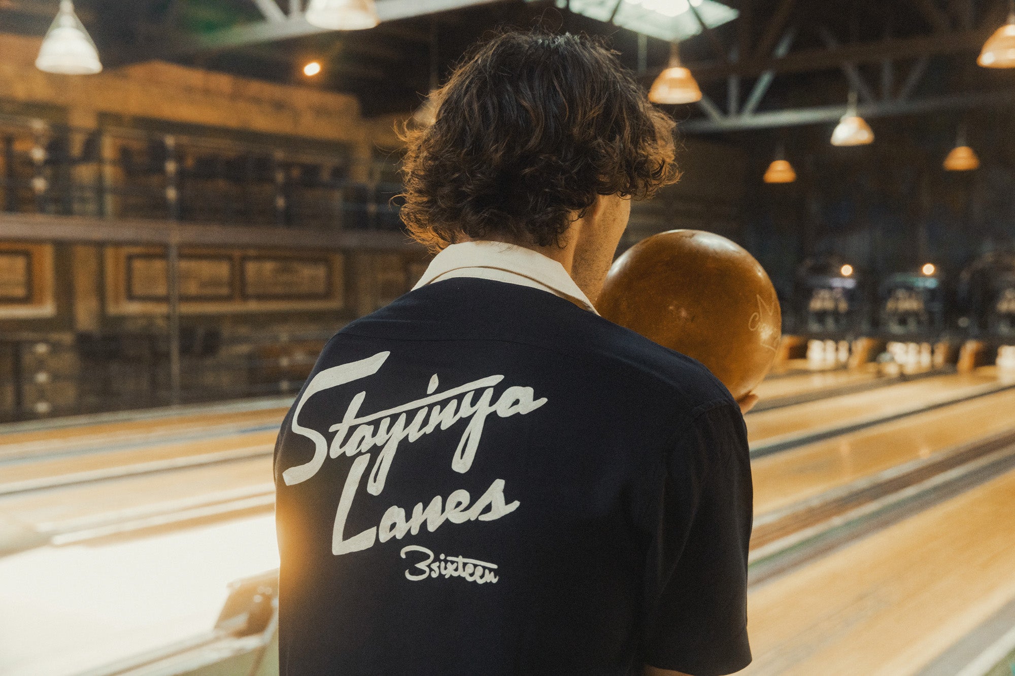 A man in a navy shirt with "Stayinya Lanes" embroidered on the back.