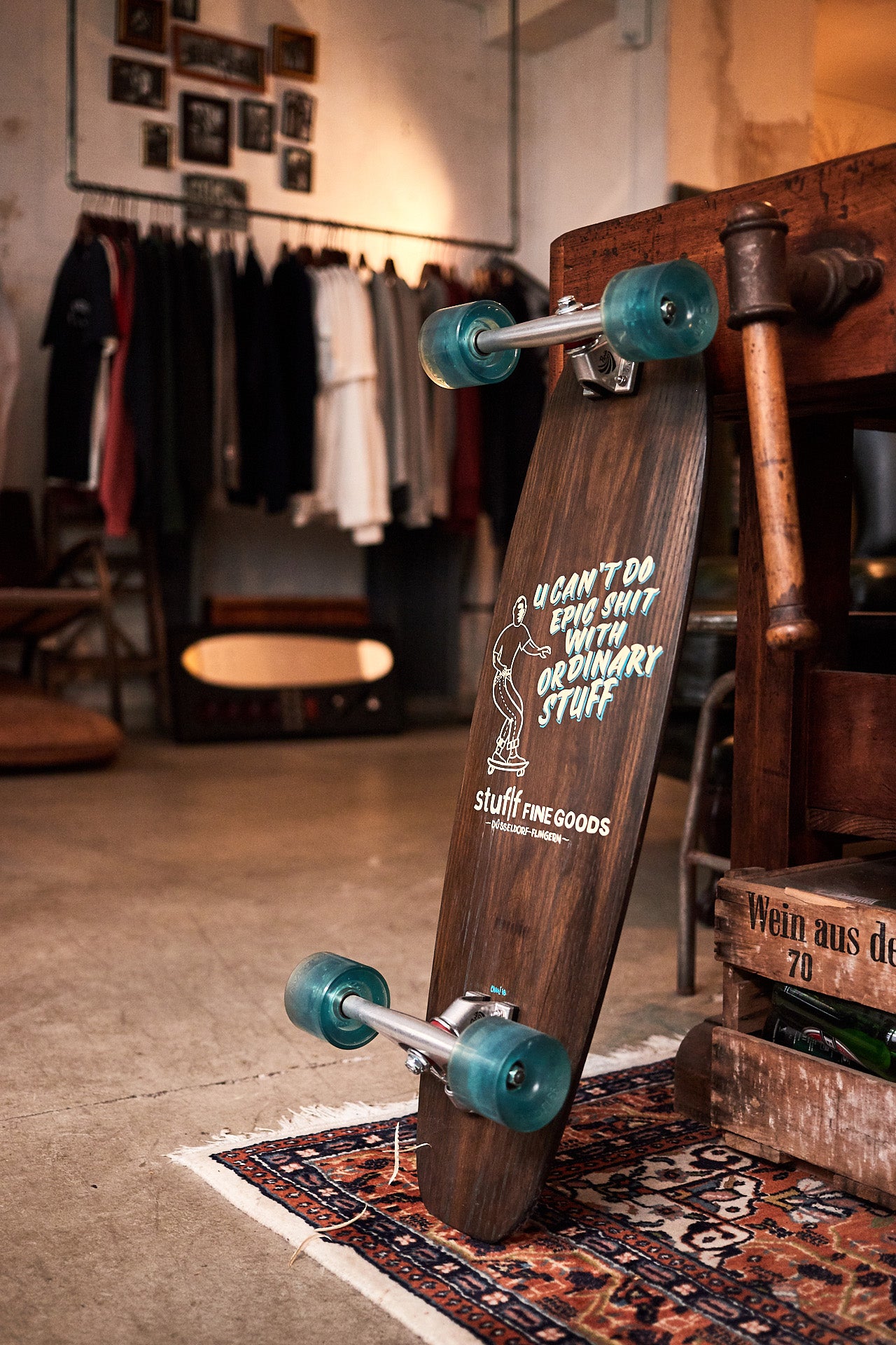 A skateboard stood on its end on a worn in rug.