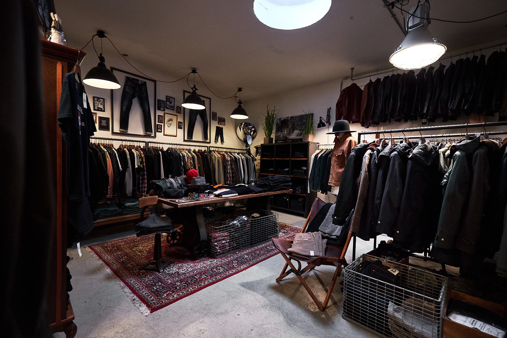 A room full of leather jackets and a hanging pendant light.