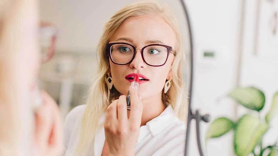 girl applying red lipstick