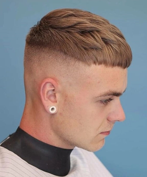 Disconnected undercut haircut with long textured top and sharp faded sides for bold style.