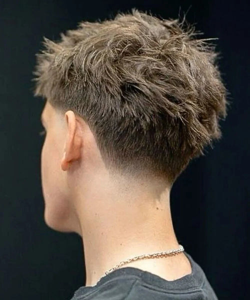Back view of low taper with voluminous, messy top and natural blend at neckline.