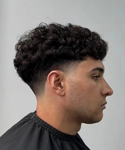Curly hair with mid taper, tight edges and bouncy defined curls on top