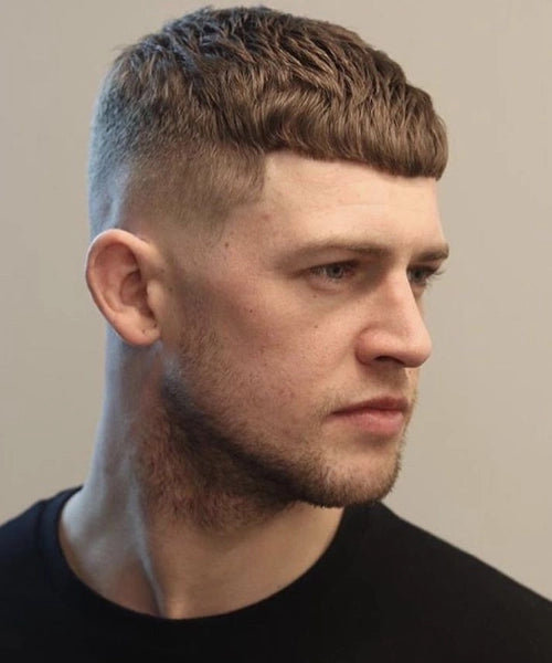 Fringe crop cut with short straight bangs and faded sides for a structured look.