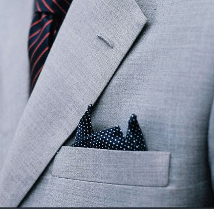 dark blue patterned pocket square in light grey suit