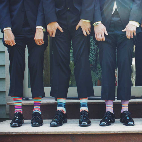 men in suits wearing colorful dress socks group photo