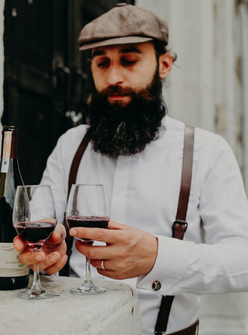 brown leather suspenders on man at wedding with wine
