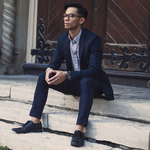 man sitting on steps with suit and no socks