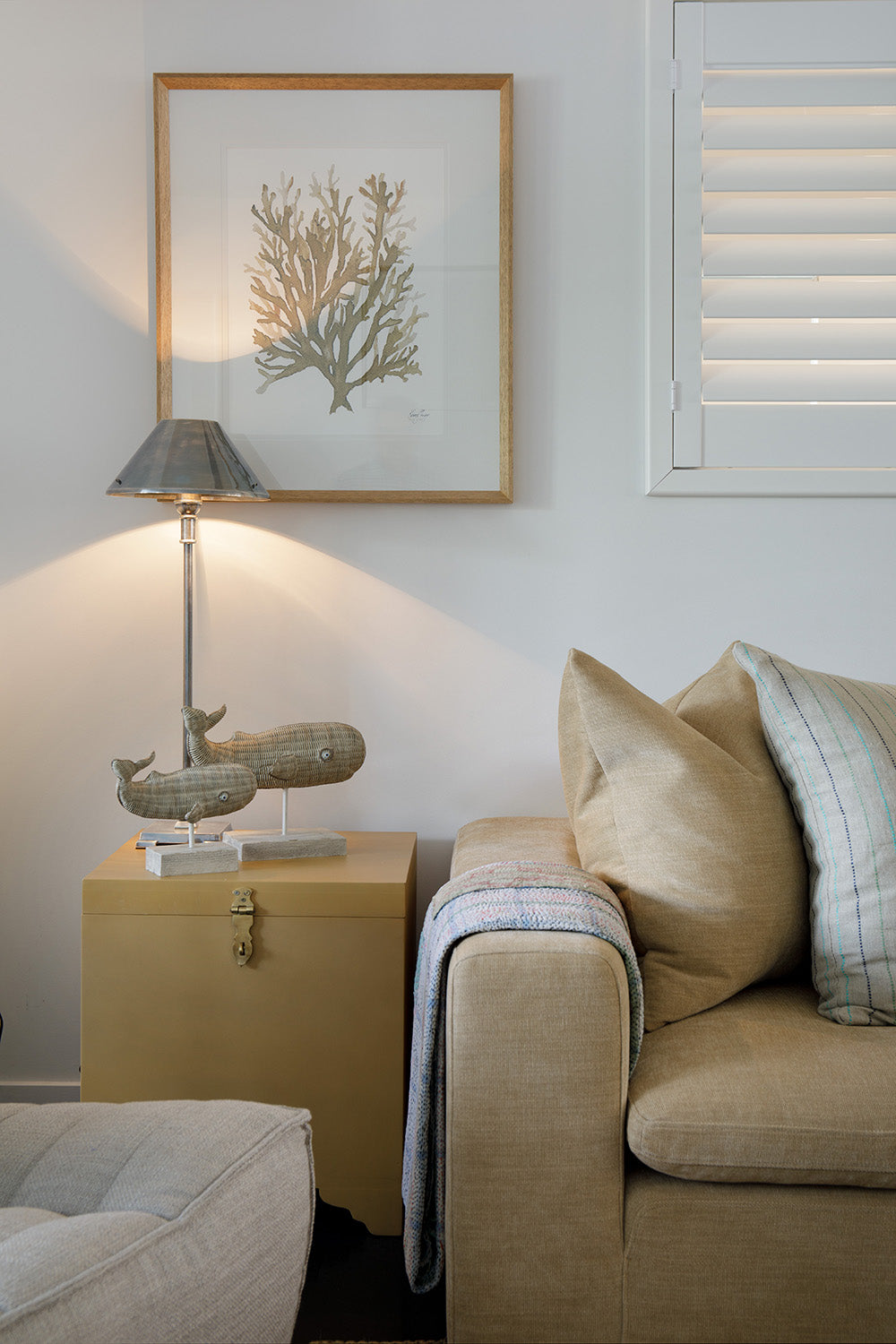 Styling by Rachel Elizabeth Interiors & Textiles. Living room feature beige couch, rattan coffee table, numerous cushions, rug, lamp and wall art