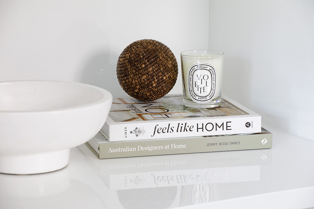 Styling by Rachel Elizabeth Interiors & Textiles. Living room bookcase with candle, white bowl, and two books