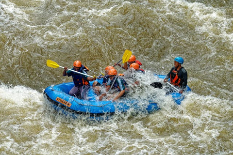 group of men paddling while inside inflatable boat