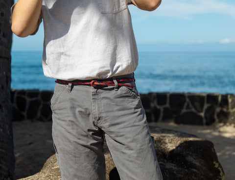 guy with a red rope belt on a beach