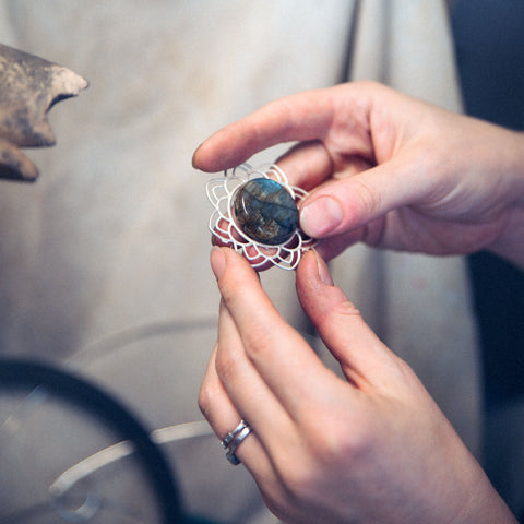 Labradorite gemstone with silver mandala held in hands