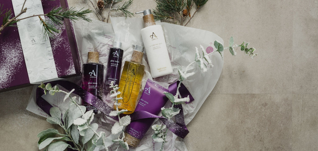ARRAN purple gift box with hand wash, hand cream, shower gel and body lotion, surrounded by frosted eucalyptus and white tissue paper