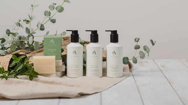 ARRAN Naturals Awaken Expression with green packaging, surrounded by eucalyptus 