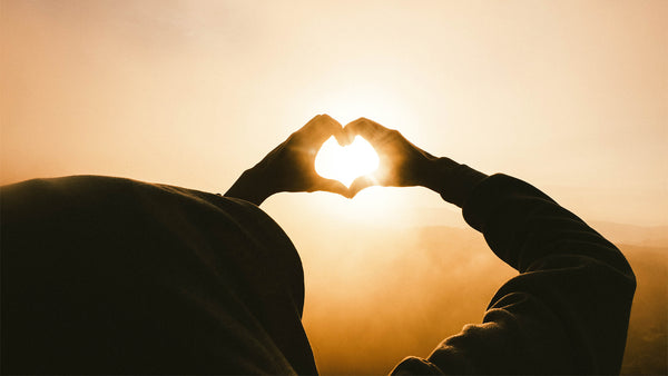 Hands held up to sun in heart shape