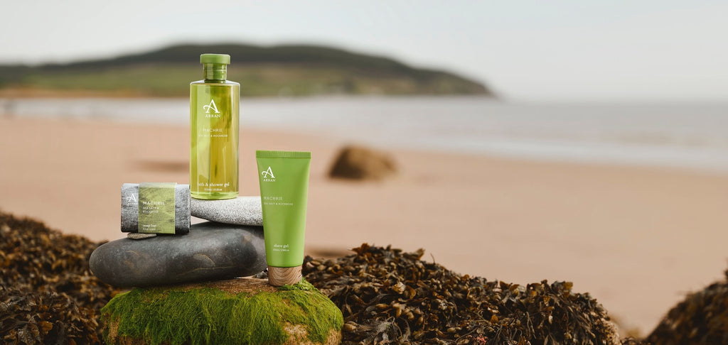 Image of men's shower gel and soap on a beach on the Isle of Arran