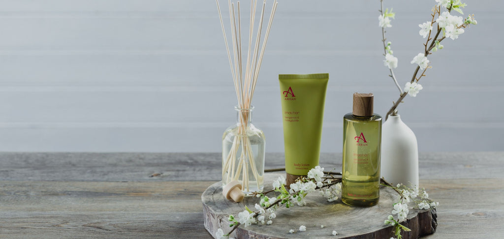 Image of green shower gel and body lotion and shower gel, placed on wooden table. 