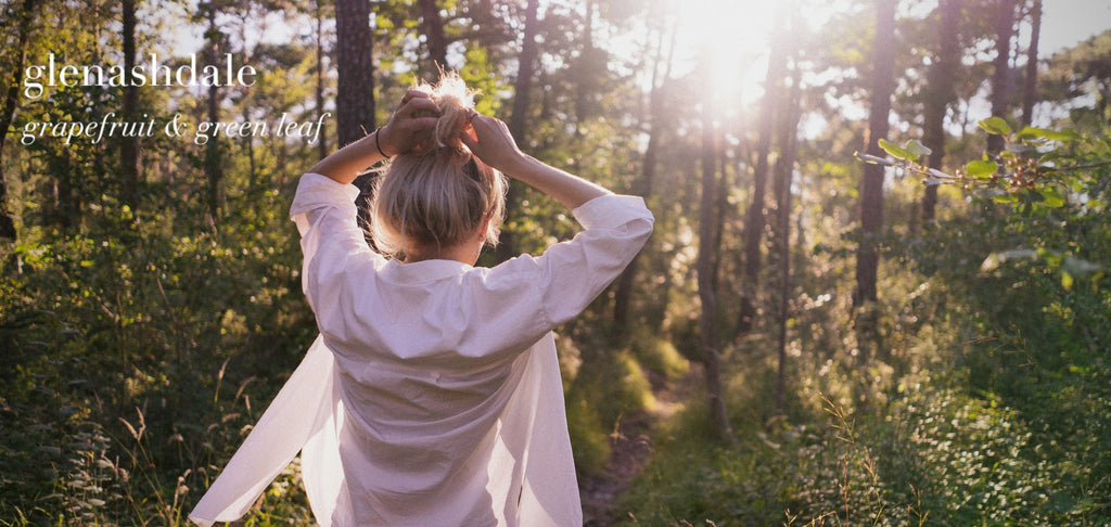 Woman walking through woodlands in summer