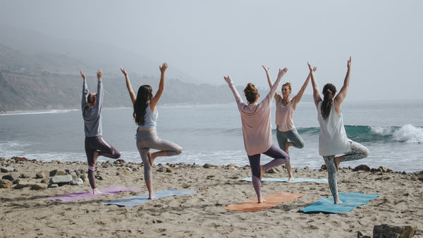 People doing Yoga on beach