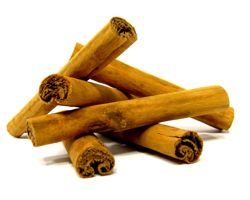 cinnamon sticks stacked up on a white background