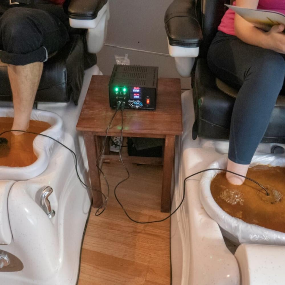 Two People performing Ionic Foot Detox Session side by side in a salon with the IonizeMe Maxx Dual