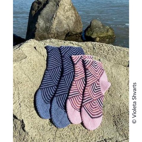 Image of Violetta Shvarts' Striped Squares Socks on a sunny rock, in a large size and a smaller size.