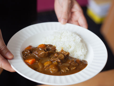 Japanischer Curryreis, präsentiert auf einem weißen Teller.