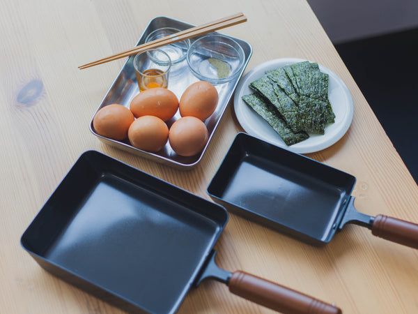 Dos sartenes de Tamagoyaki junto con huevos y alga nori