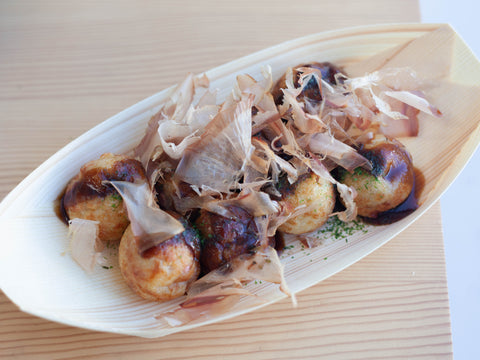 Empanadillas japonesas de pulpo takoyaki cubiertas con hojuelas de bonito