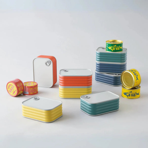 Set of colorful tin-shaped bento boxes on a table with some fish tins