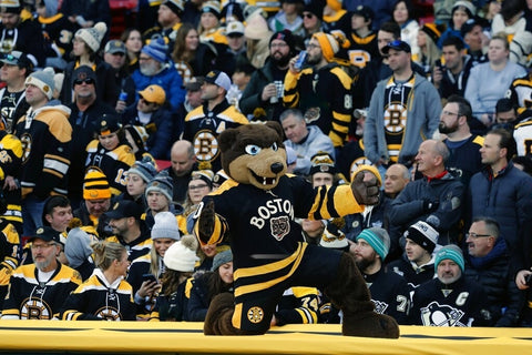 A hockey game being played at Fenway Park with a large crowd in the stands