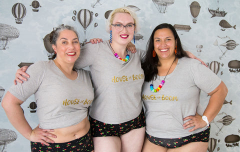 three babes in plus-size grey cotton t-shirts with "HOUSE OF BOOM" screenprinted on them