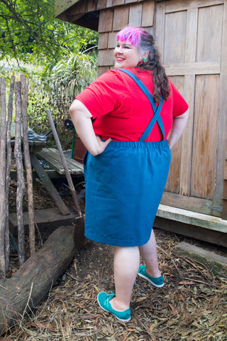 a fat babe in a cotton pinafore with crossed straps