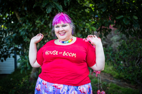 A fat babe in an organic cotton red t-shirt that says HOUSE OF BOOM across it