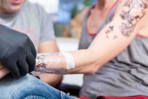 A tattoo artist relieving tattoo pain with proper aftercare.