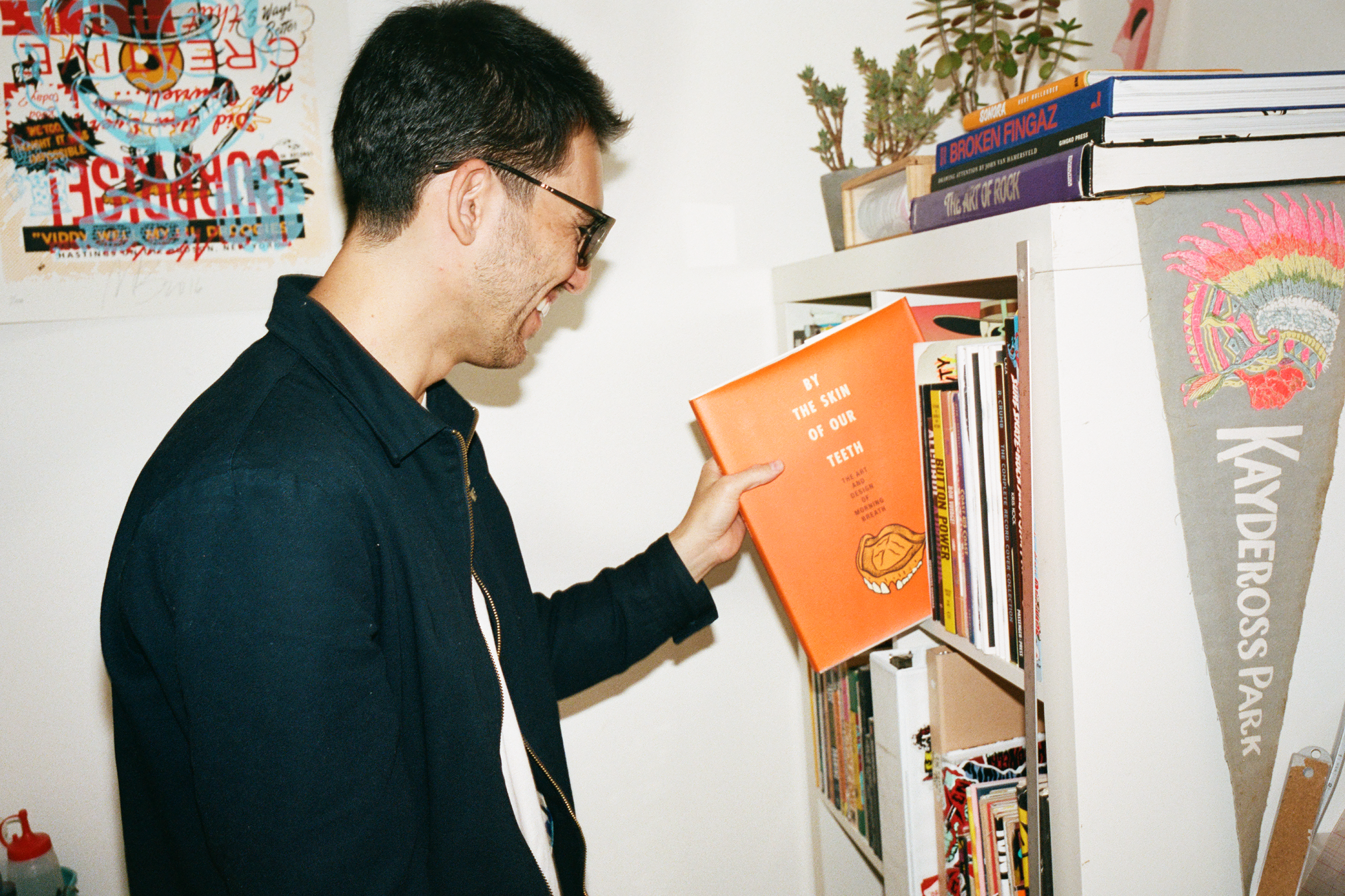 Daniel Shepard reaching for a book on his bookshelf