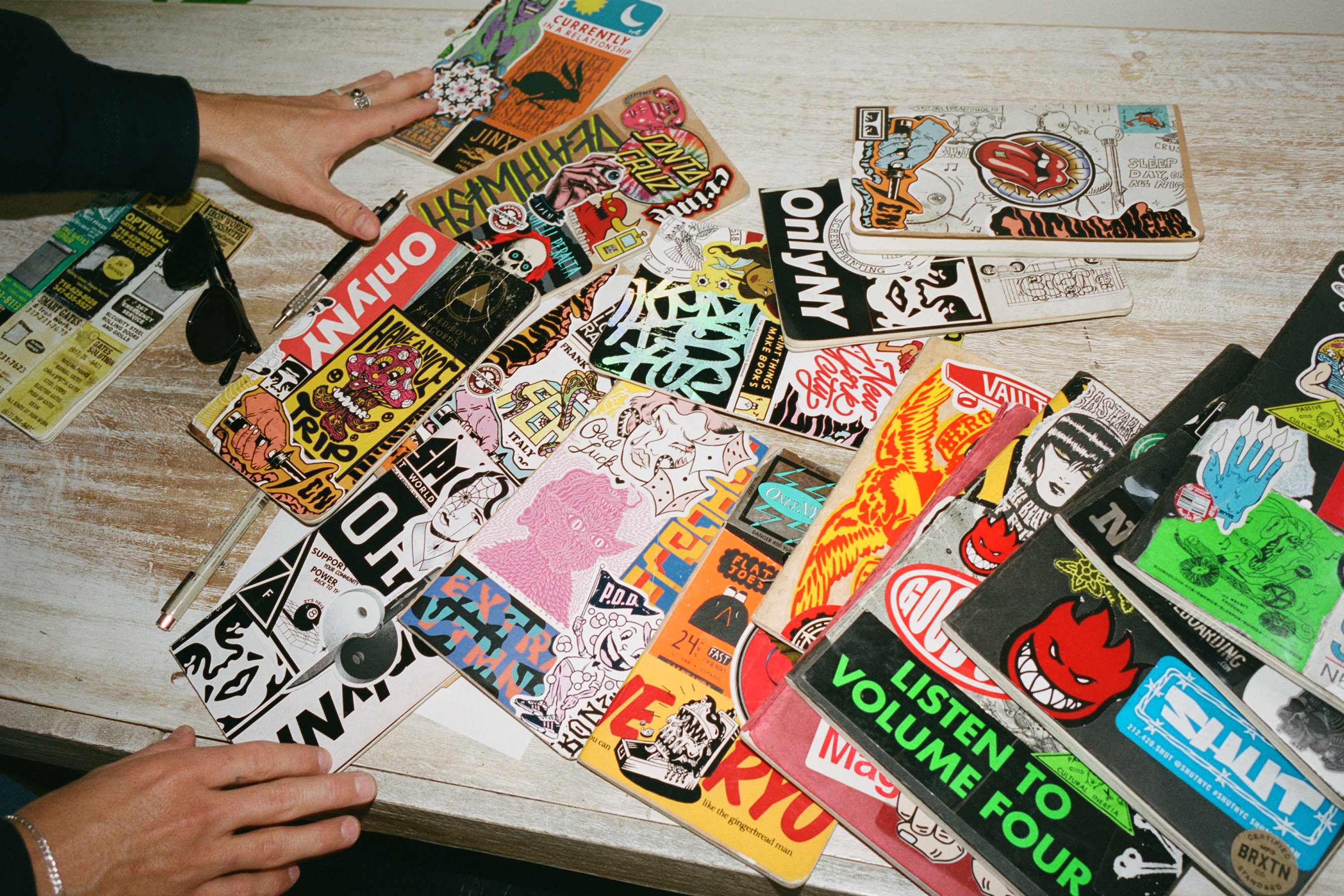 Daniel Shepard shows the sticker collages on the covers of his sketchbooks