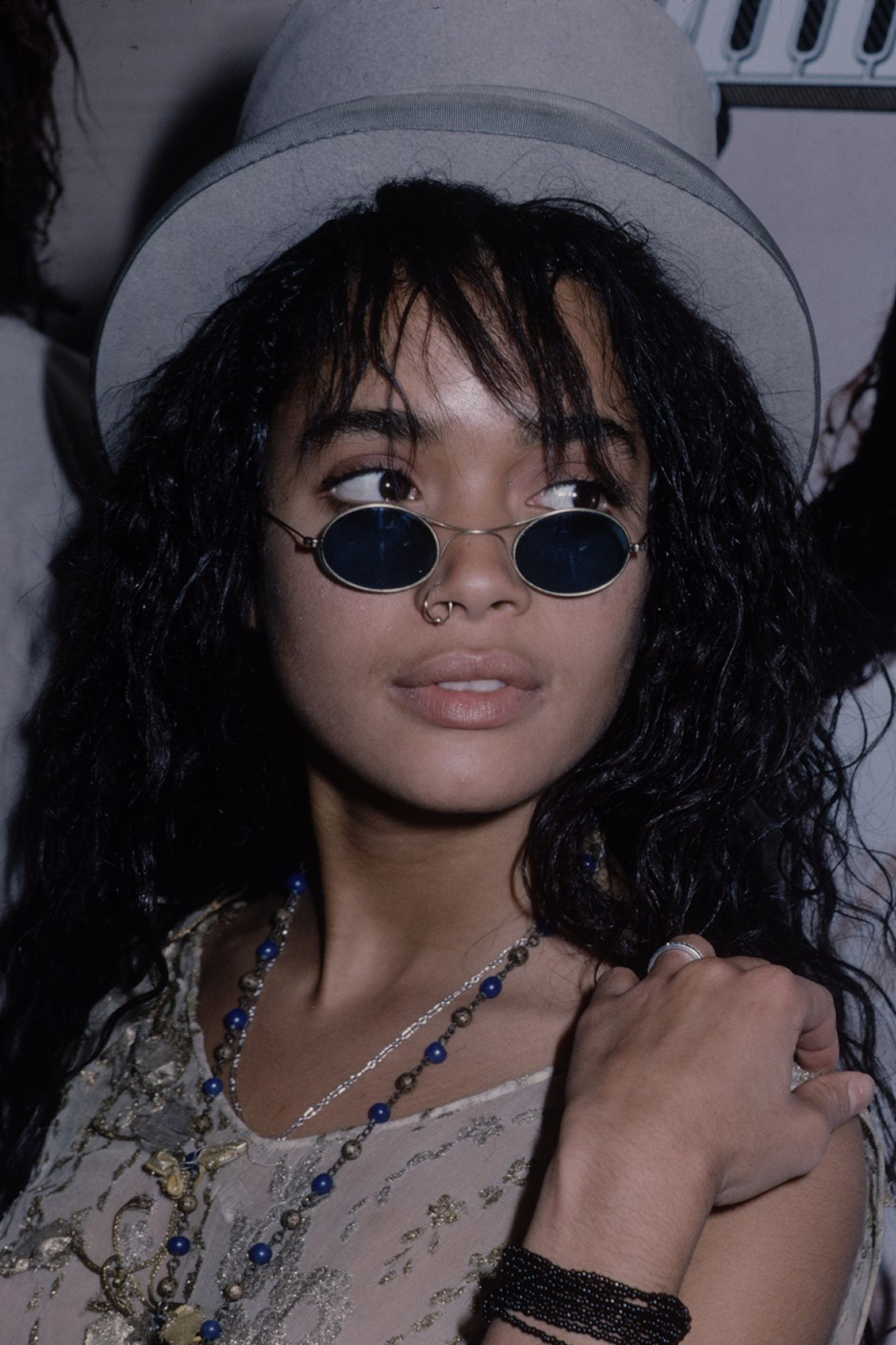 Woman wearing small, oval shape sunglasses with black lenses