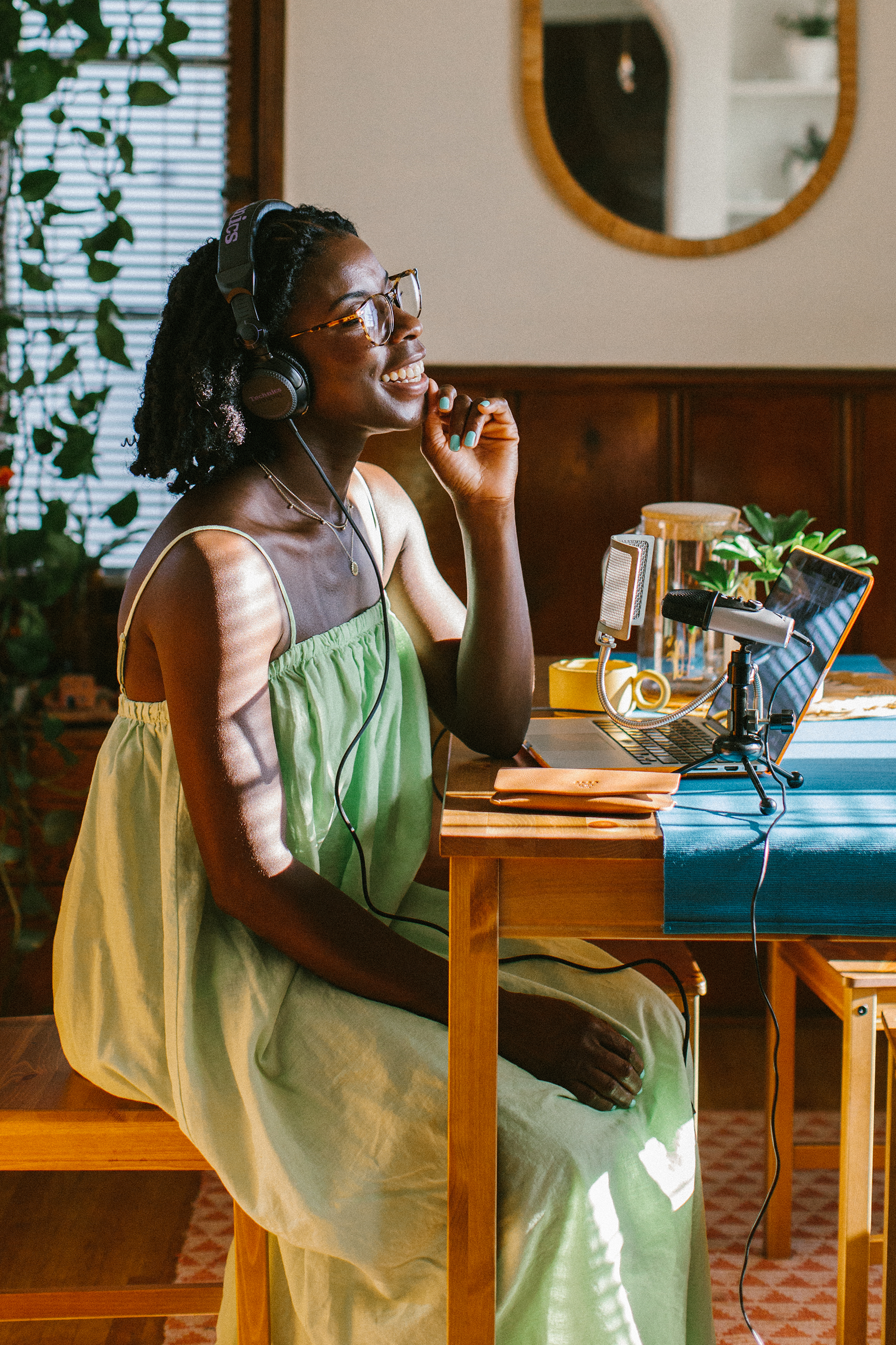 Dr. Yewande sitting at her dining room table talking into a microphone