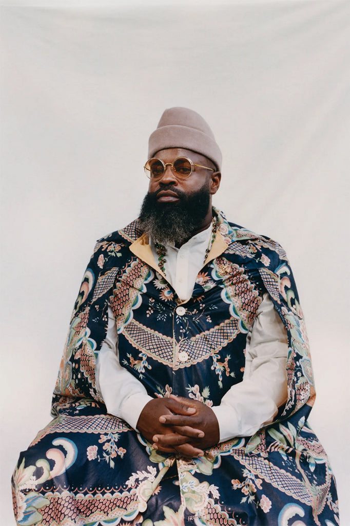 Black Thought wearing round, orange tinted sunglasses and a beanie