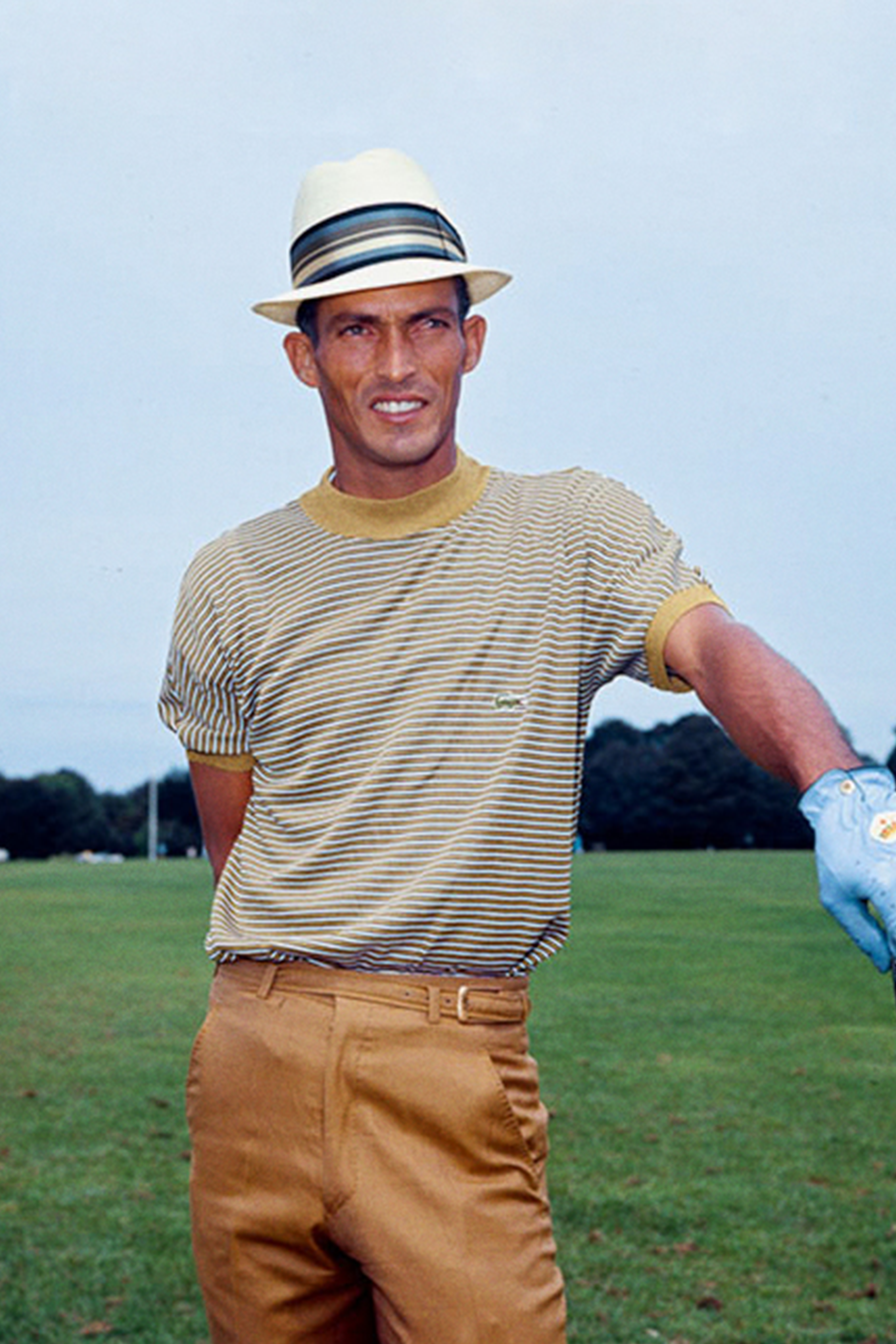 Chi Chi Rodriguez wearing a fedora and a striped t-shirt on the golf course