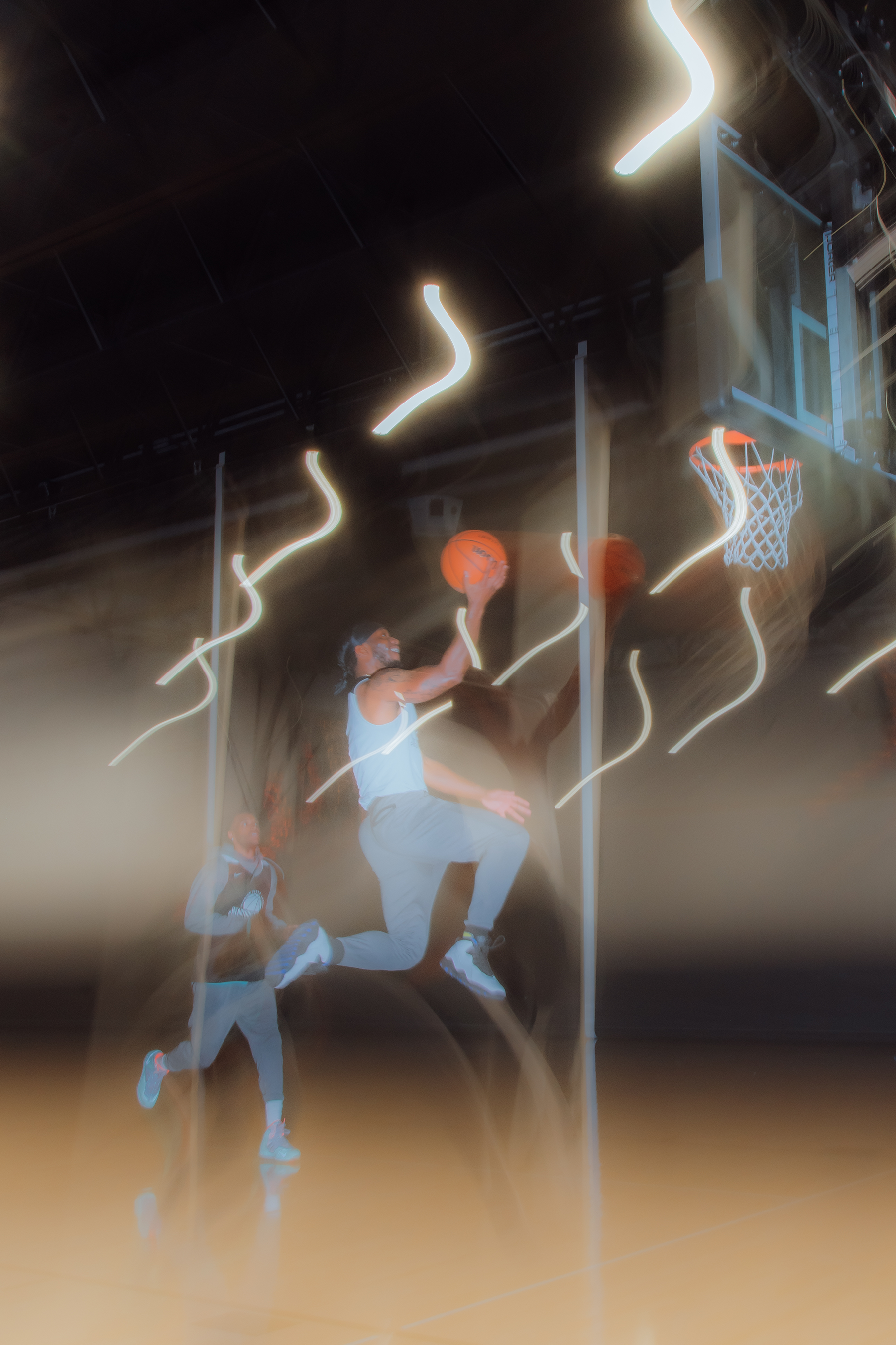 A man jumping to throw a basketball in the hoop