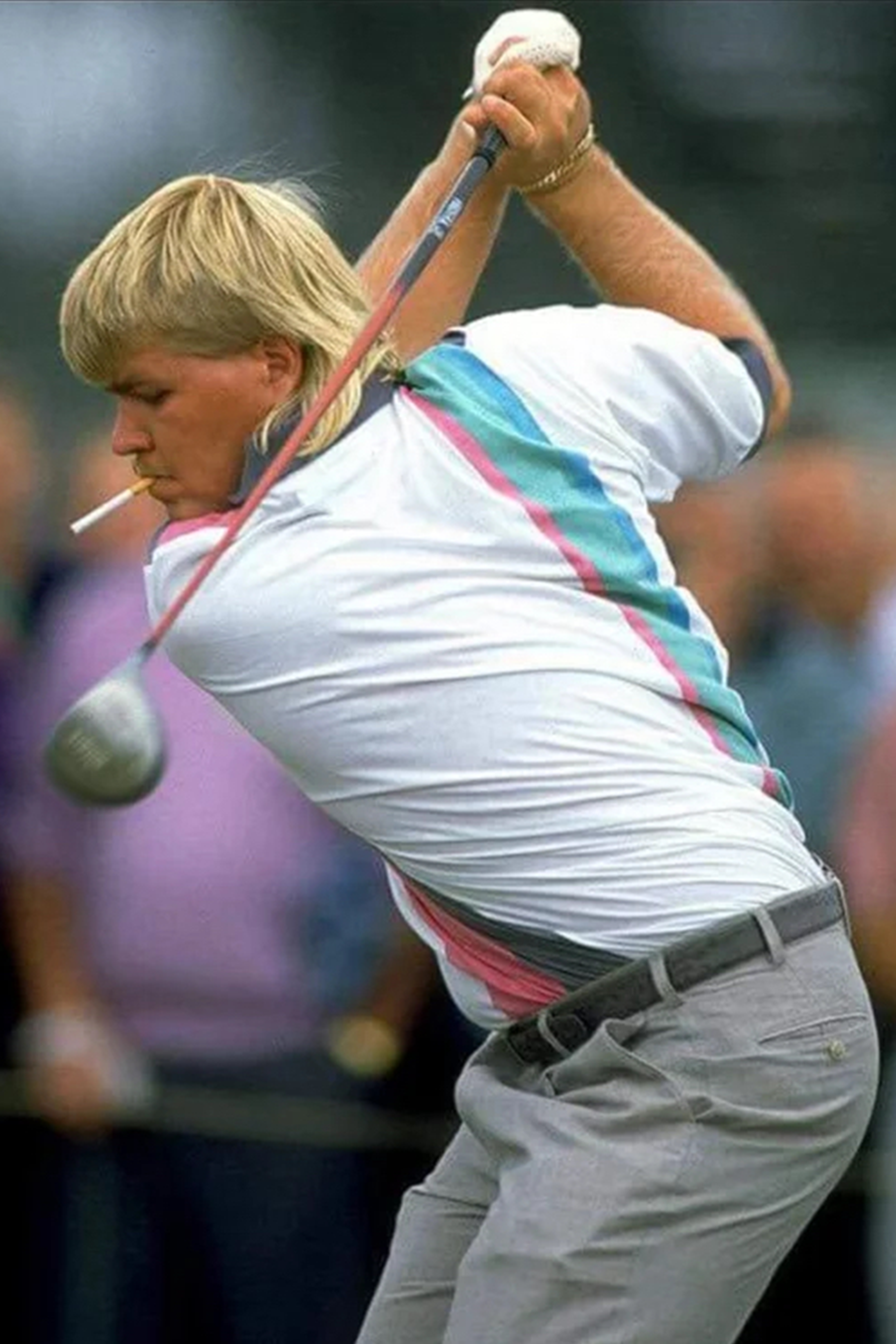 Young John Daly in a golf tournament wearing a polo with a cigarette in this mouth