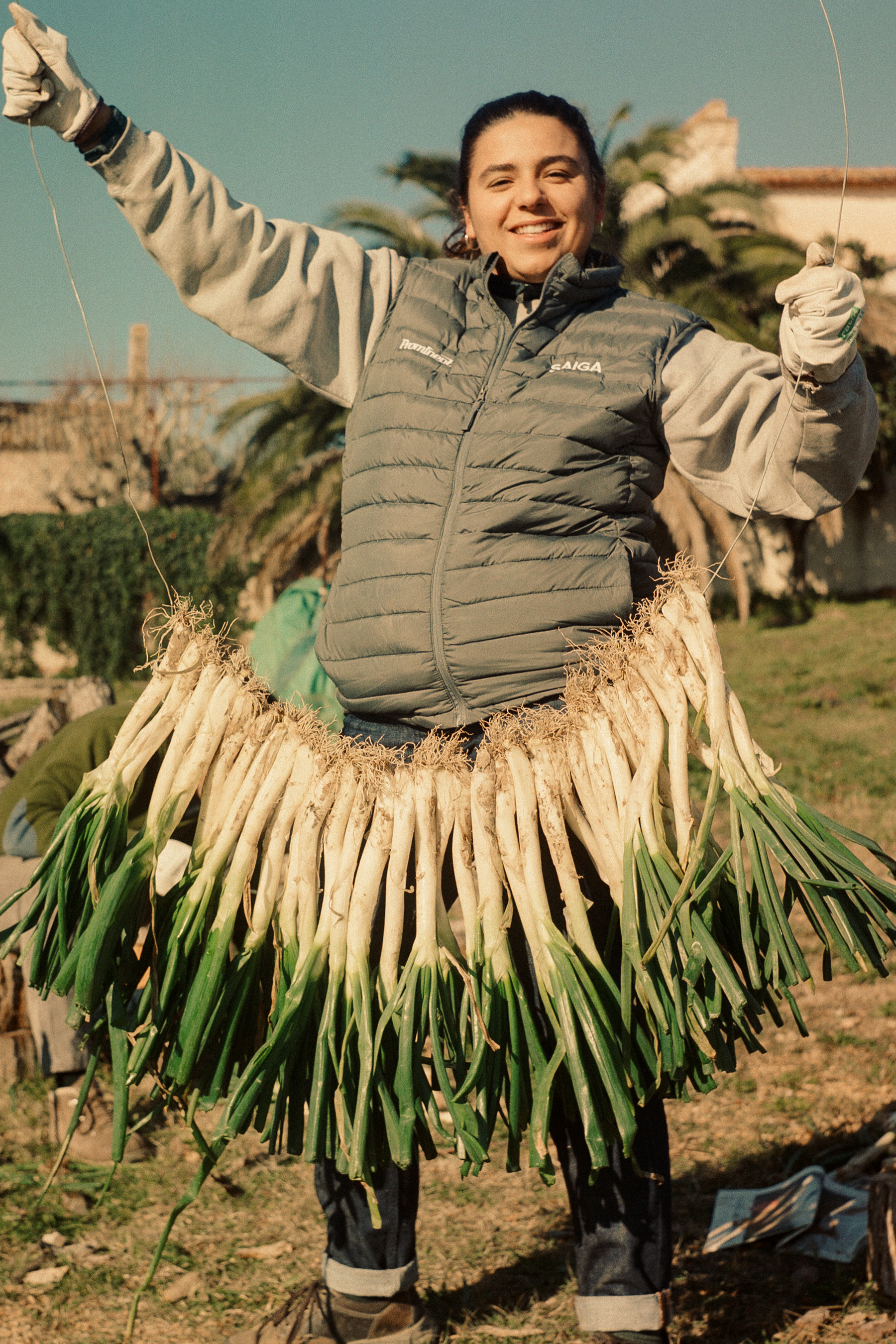 A woman in Catalonia carrying a garland of pulled green onions called Calçots